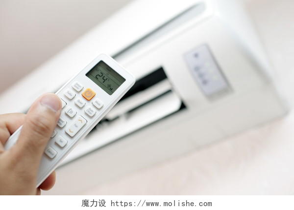 空调房间和远程控制切换到所需的度数的手在墙上